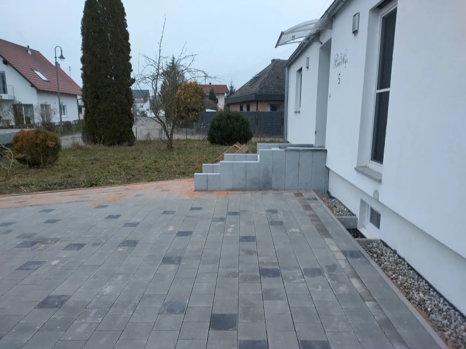 Hofeinfahrt aus Betonpflaster mit Granittreppe und Dränrohr